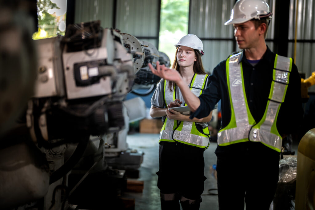 factory engineers inspect on machine. confident team mature busi